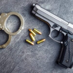 Pistol bullets, handgun and handcuffs.