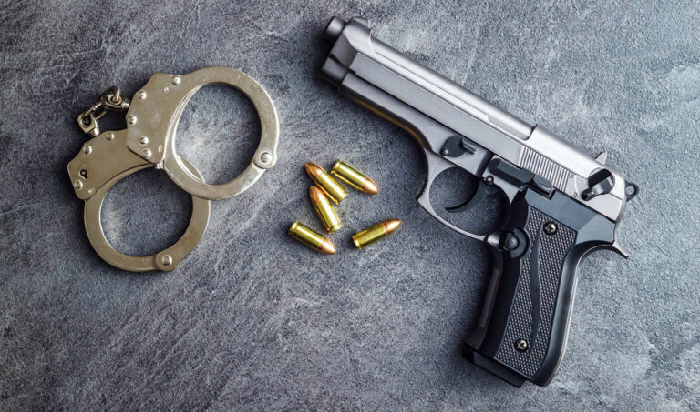 Pistol bullets, handgun and handcuffs.